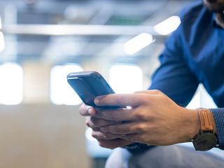 moški drži v rokah mobilni telefon