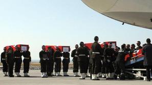 Krste s trupli turških vojakov, ki so umrli med napadi, nalagajo na letalo.