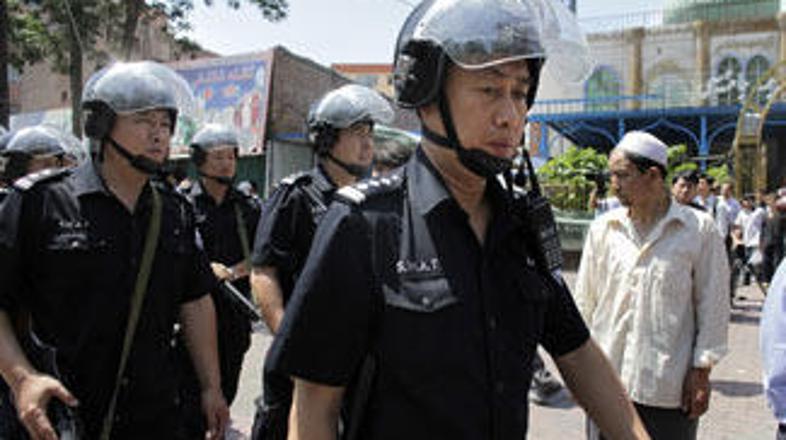 Kitajski policisti pred vhodom v mošejo v Urumqiju.