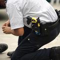 Policist pospravlja žice taserja, ki ga ima spravljenega za pasom.