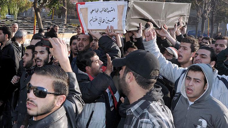 Študentje nosijo krsto s truplom v torek ustreljenega kolega.