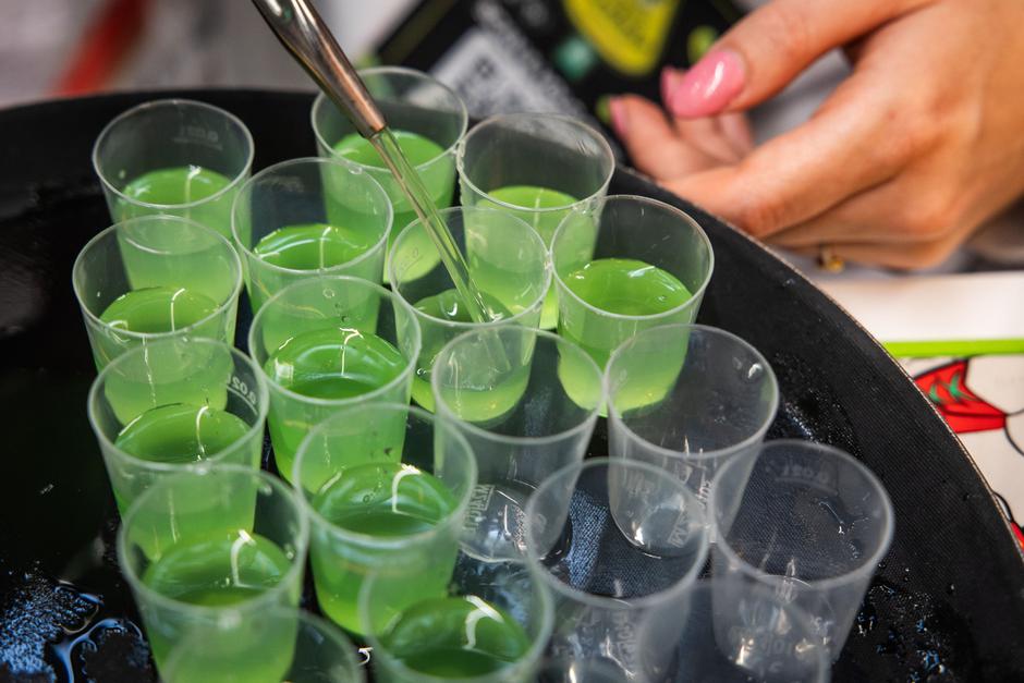 Točenje zelene pijače v male kozarčke | Avtor: Profimedia