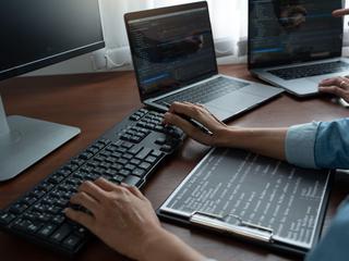 Programerji z računalniki na mizi delajo