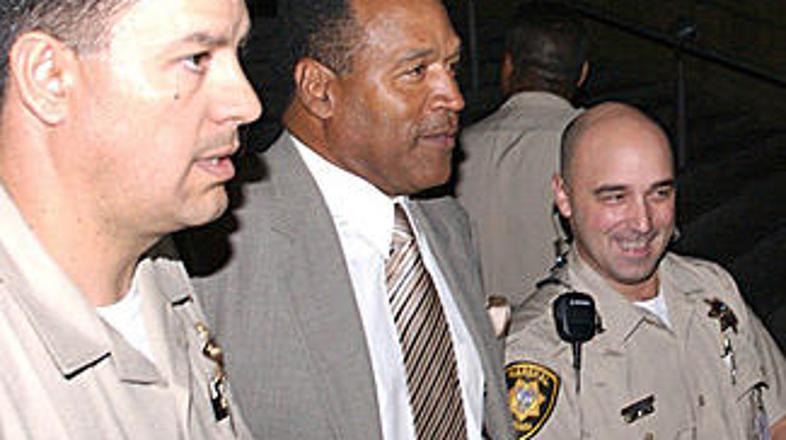 O. J. Simpson v spremstvu šerifov zapušča sodišče.