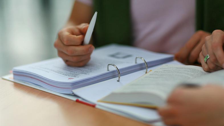 Roke na fasciklu in knjigi