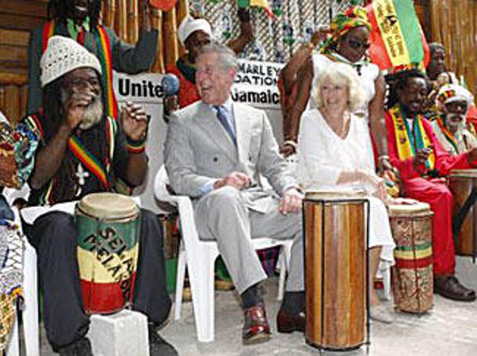 Charles in Camilla v krogu domačinov igrata na bobne.