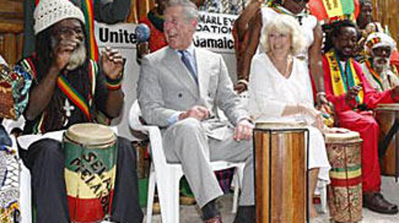 Charles in Camilla v krogu domačinov igrata na bobne.