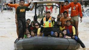 Reševalci z natrpanim čolnom rešenih Filipinčanov.