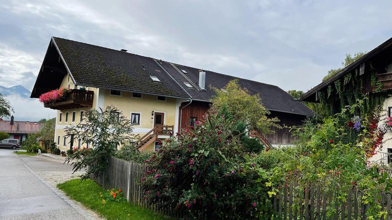 ograja ob cesti v ozadju poslopja