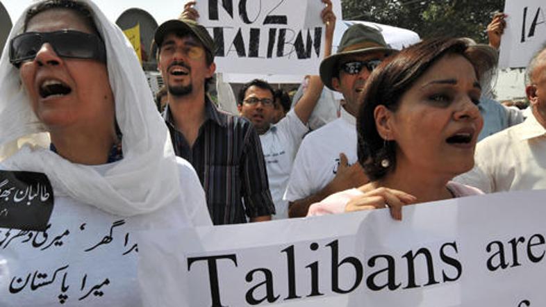 Prebivalci Pakistana s transparenti, na katerih je zapisano, da so talibani sovr