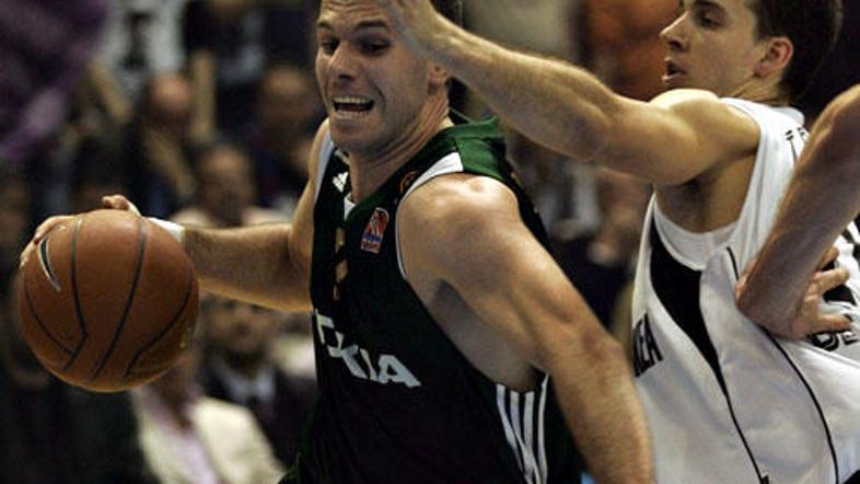 Sani Bečirovič v prodoru mimo košarkarja Partizana Uroša Tripkovića