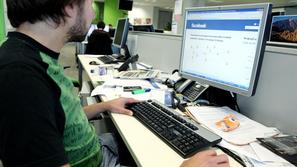 slovenija 11.11.09 facebook na delovnem mestu, oseba na racunalniku pregleduje s