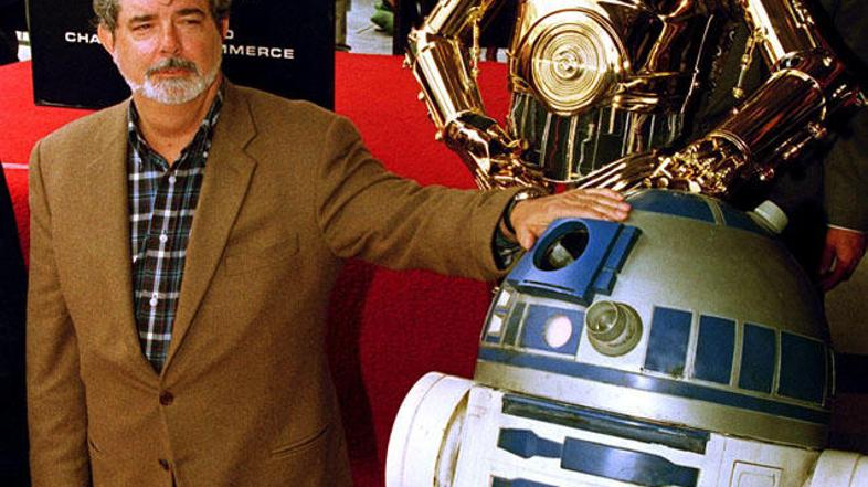 Ustvarjalec Vojne zvezd George Lucas (L) pozira skupaj z junakoma sage R2D2 in C