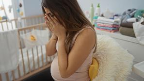 objokana nosečnica v opremljeni otroški sobi