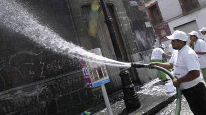 Vladni delavci čistijo zgradbe v glavnem mehiškem mestu.