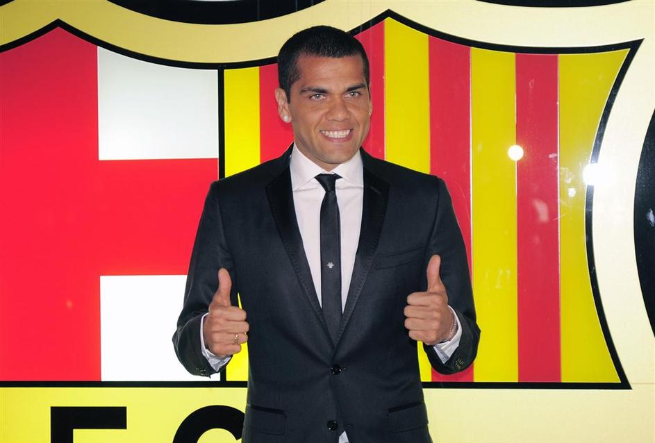 Alves je takole poziral ob podaljšanju pogodbe z Barço do 2015. (Foto: Reuters)