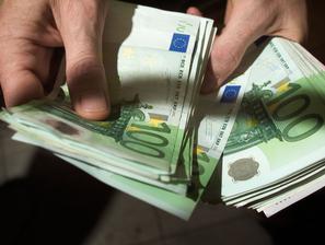 Moški v roki drži denar evre