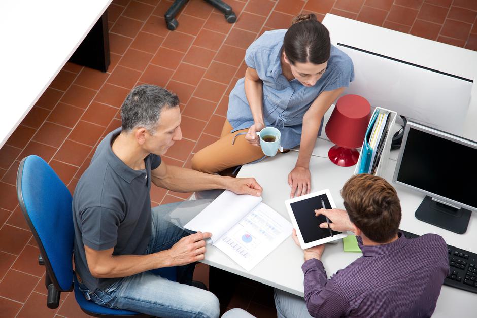 Sodelavci v pisarni sedijo in se pogovarjajo | Avtor: Profimedia