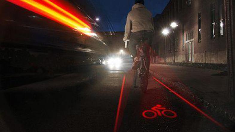 Laser, pritrjen na ohišje kolesa, projicira kolesarsko stezo na podlago.