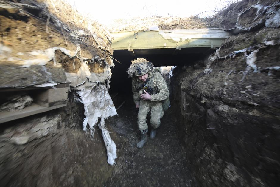 Ukrajinski vojak preverja razmere na položaju blizu vasi Zaytseve, nedaleč od mesta Gorlivka, ki ga nadzorujejo proruski separatisti, območje Donecka, Ukrajina | Avtor: epa