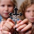 Otroci držijo križ