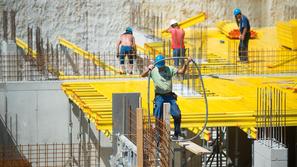 Gradbeni delavci med delom na žgočem soncu.