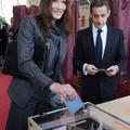 Prva dama Carla Bruni-Sarkozy s soprogom Nicolasom Sarkozyjem na volišču. (Foto: