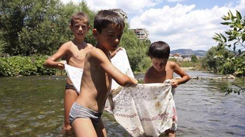 Albanski otroci se igrajo v mejni reki Ibar, ki etnično deli Kosovo med Srbe in 