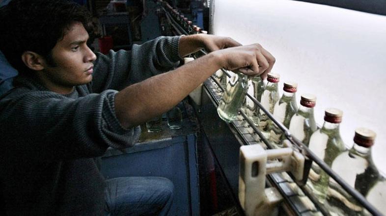 Sodelavec podjetja Murree Brewery razvršča steklenice.