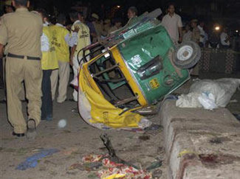 Množica ljudi si ogleduje posledice eksplozije.