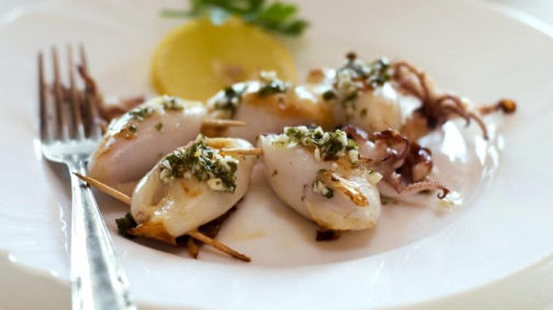 Polnjene lignje postrezite s tržaško omako in limono.