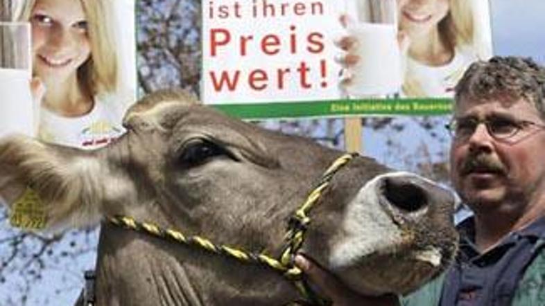 Nezadovoljni kmet je na proteste prišel s kravo in s transparentom, na katerem p