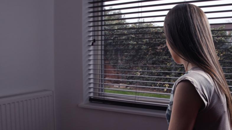 Ženska gleda skozi okno