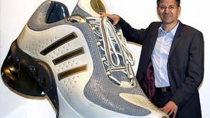 Herbet Hainer z nasmehom predstavlja novi model tekaškega čevlja.