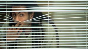 Moški gleda skozi okno