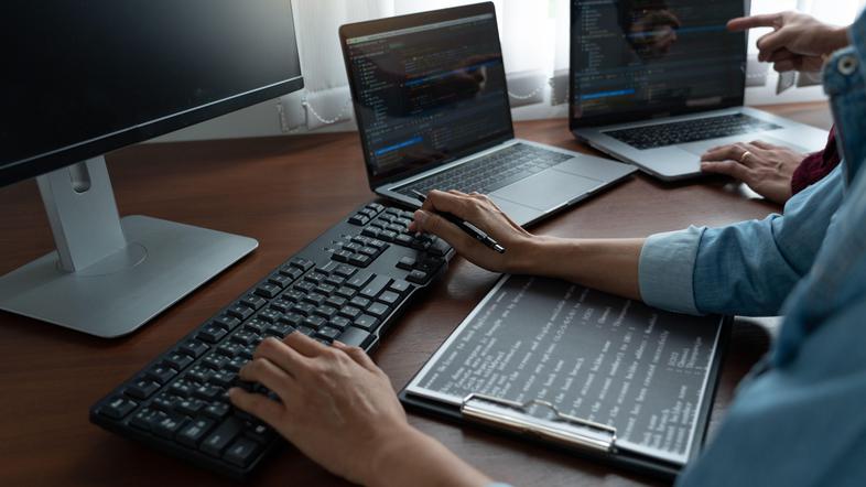 Programerji z računalniki na mizi delajo