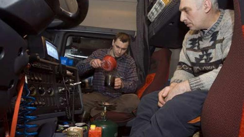 Beloruska voznika tovornjaka si že peti dan pripravljata večerjo v kabini svojeg