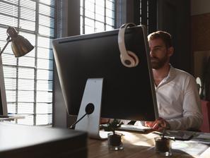 Moški sedi za računalnikom