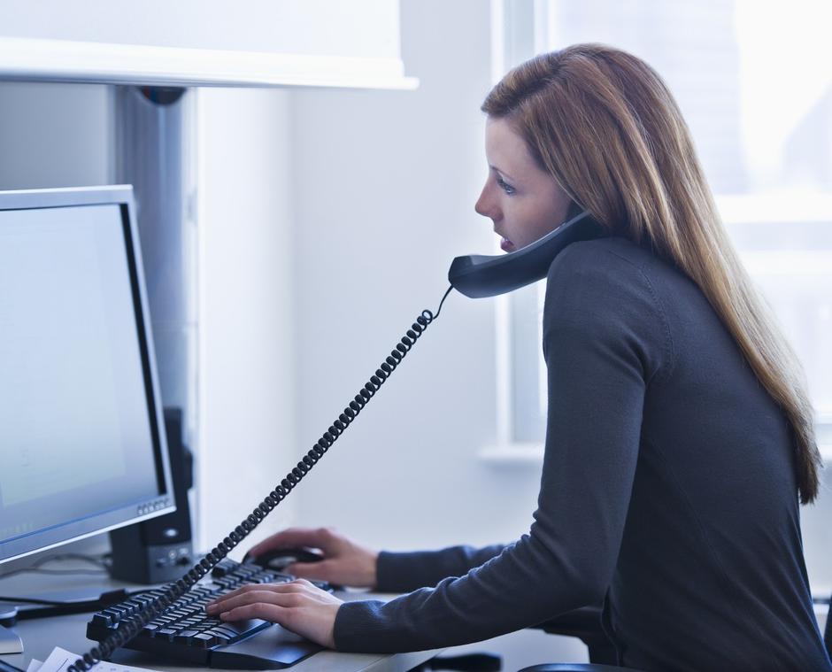 ženska v pisarni za računalnikom na telefonu | Avtor: Profimedia