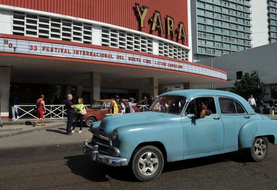 Za Kubo tipičen avtomobil pred kinom v Havani decembra 2011.