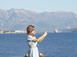 turistka se slika ob vodi Kotor