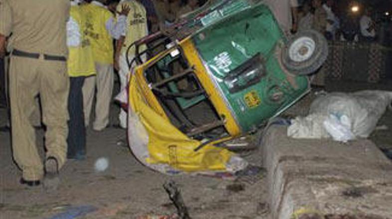 Množica ljudi si ogleduje posledice eksplozije.