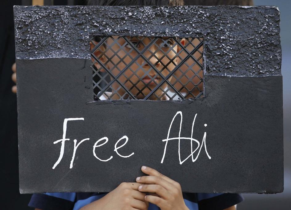 Deček na protestih proti priprtju 12-letnega Alija Hasana, obtoženega protestira